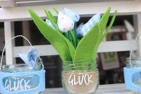 Dekogläser mit der Aufschrift Glück, gefüllt mit Sand und Stoffblumen in Blau und Weiß