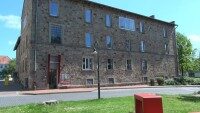 Kunstverein in der alten Honigfabrik in Ibbenbüren Ein Sandstein Gebäude in der Innenstadt von Ibbenbüren. Im Vordergrund sind ein paar Gräser und gelbe Blumen