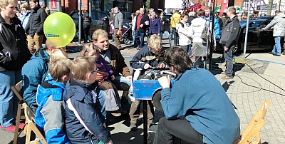 Viele Menschen laufen durch Ibbenbüren. Kinder schauen sich ein Modell von einem Automotor an