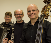 Tango meets Klezmer Drei Musiker mit schwarzen Hemden und Musikinstrumenten in der Hand.